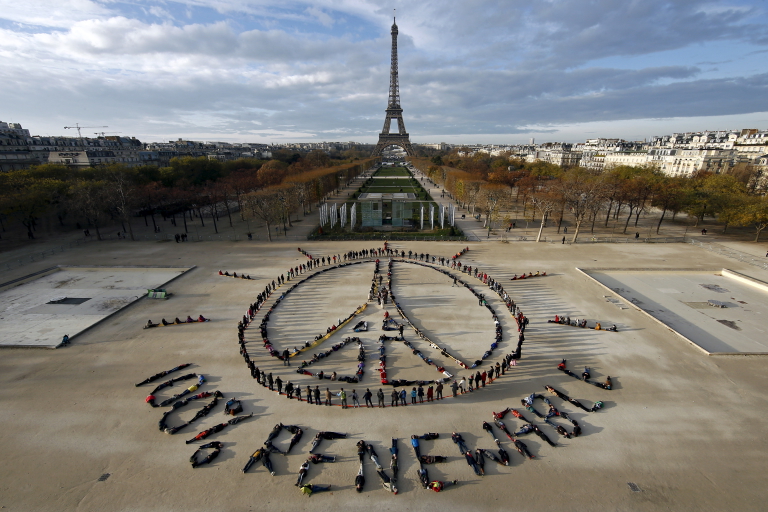 Cientos de ecologistas colocan sus cuerpos para formar un mensaje de esperanza y de paz frente a la Torre Eiffel (REUTERS/Benoit Tessier)