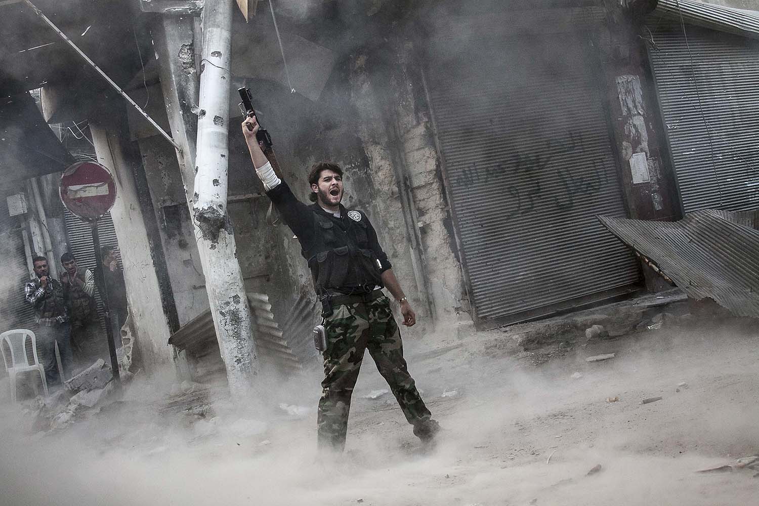 Especial Siria. Un rebelde celebra el lanzamiento de un misil contra las fuerzas del presidente.
