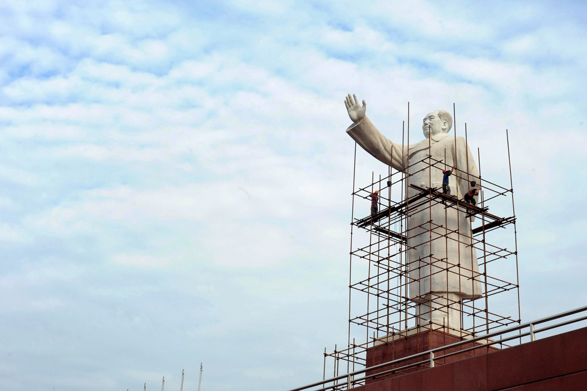 Los obreros limpian la estatua de Mao Zedong para celebrar el 64º aniversario de la República China