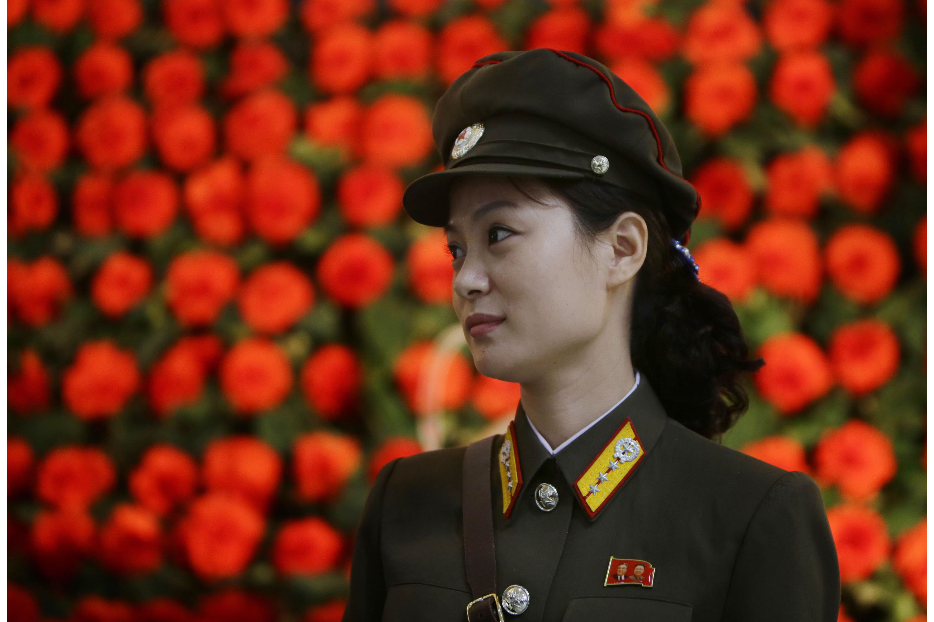 Una soldado norcoreana, con un broche de los expresidentes Kim Il-sung y Kim Jong-il en la solapa, e