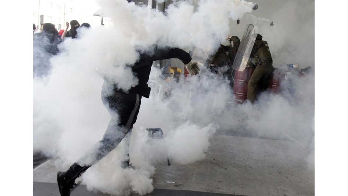 Especial Chile. Un activista repele los gases lacrimógenos durante una manifestación