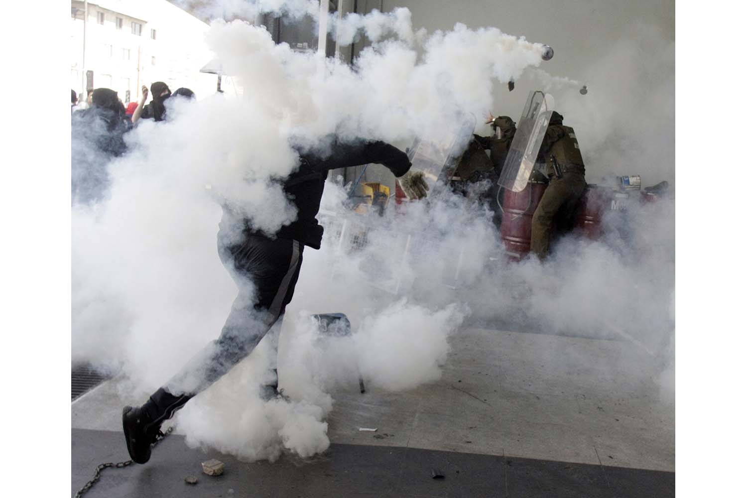 Especial Chile. Un activista repele los gases lacrimógenos durante una manifestación
