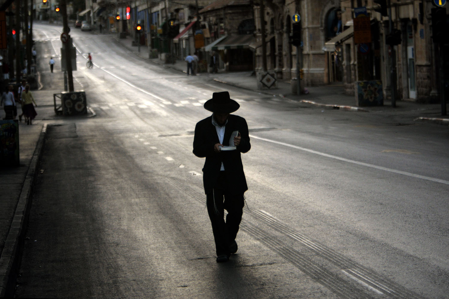 Especial Israel. Un judío ortodoxo reza mientras va caminando por una calle vacía de Jerusalén