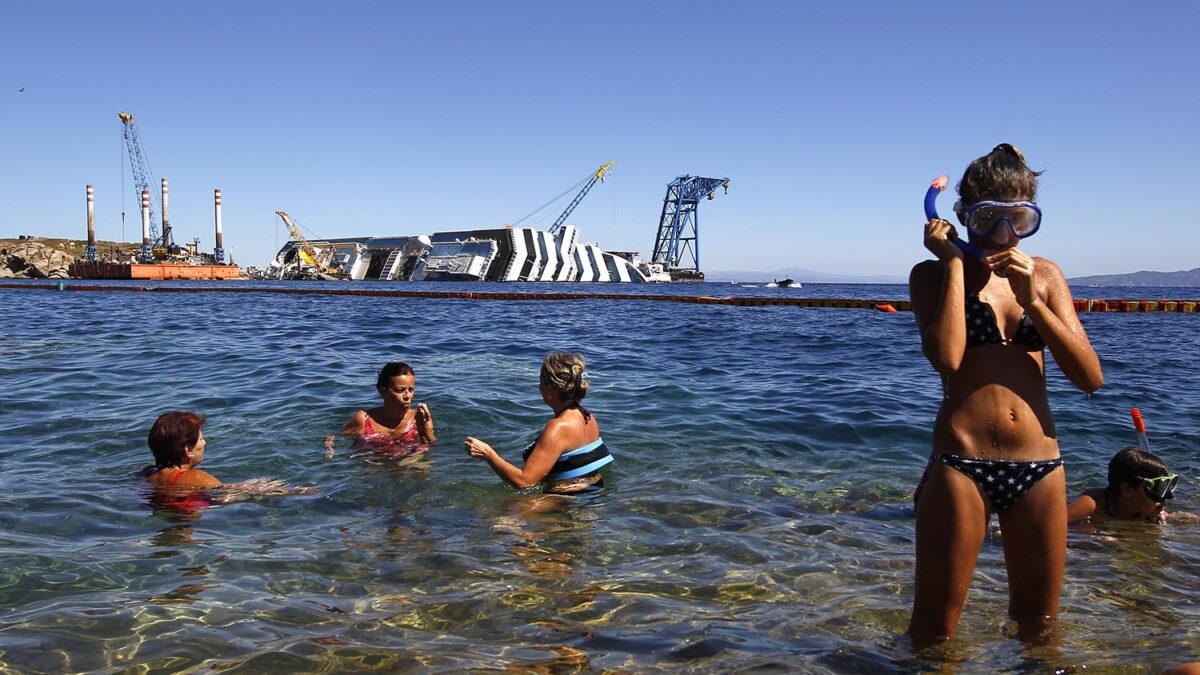 Especial Un mundo pequeño. Unos turistas se bañan en la zona del naufragio del Costa Concordia