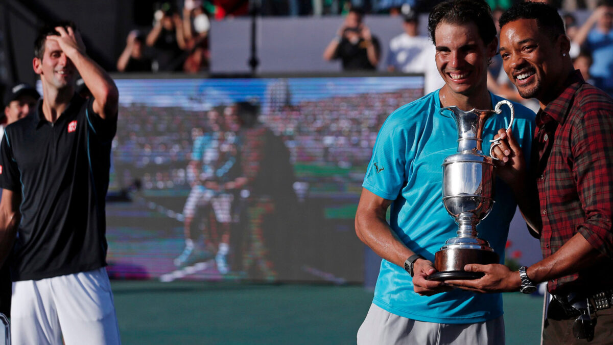 Rafa Nadal recibe un trofeo de manos del actor Will Smith tras ganar a Djokovic.