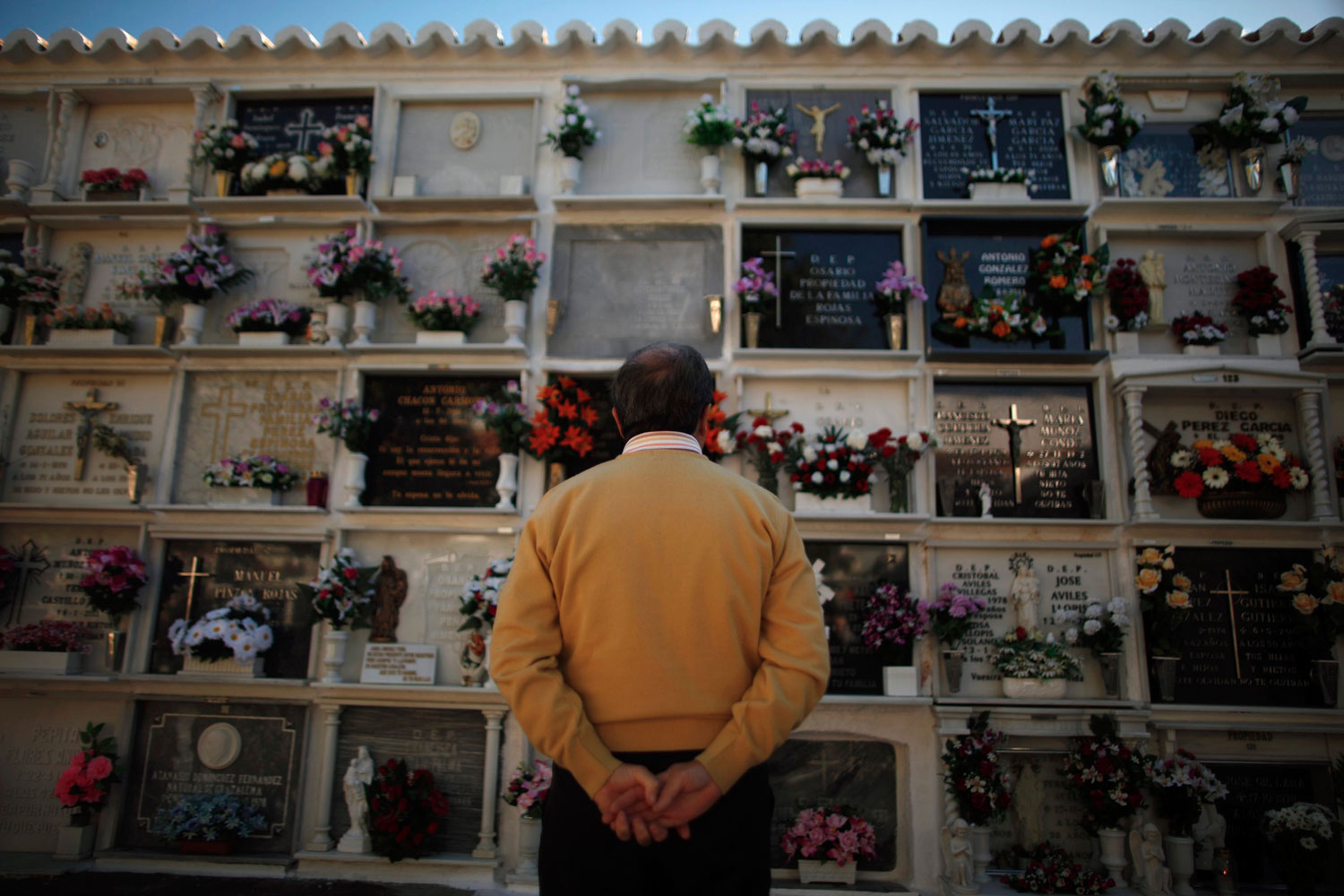 Flores y oraciones en los cementerios de España en el día de Todos los Santos