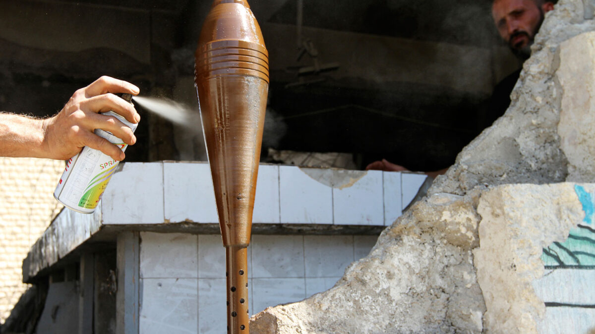 Un combatiente pinta con aerosol un proyectil de mortero improvisado en Aleppo.