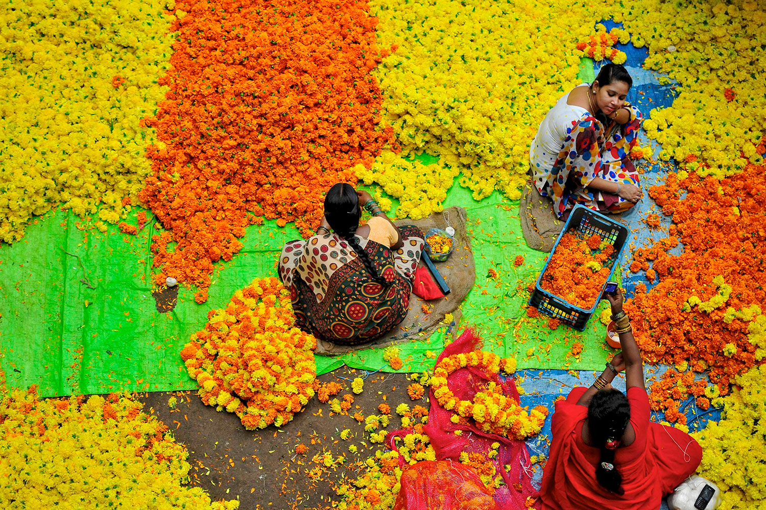 Cosen y trenzan las flores artesanalmente en Bangalore.