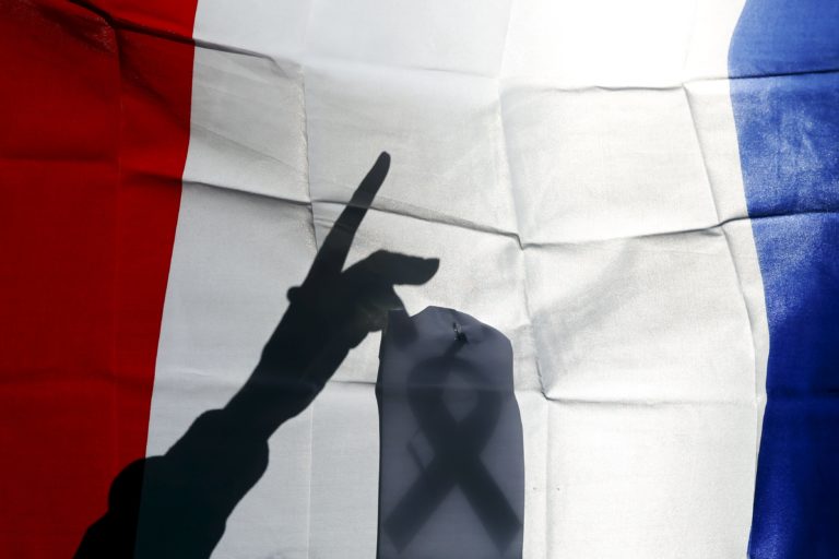 Un Guardia Civil coloca una cinta de duelo en una bandera francesa durante una manifestación en Madrid, España (REUTERS/Susana Vera)   TPX IMAGES OF THE DAY