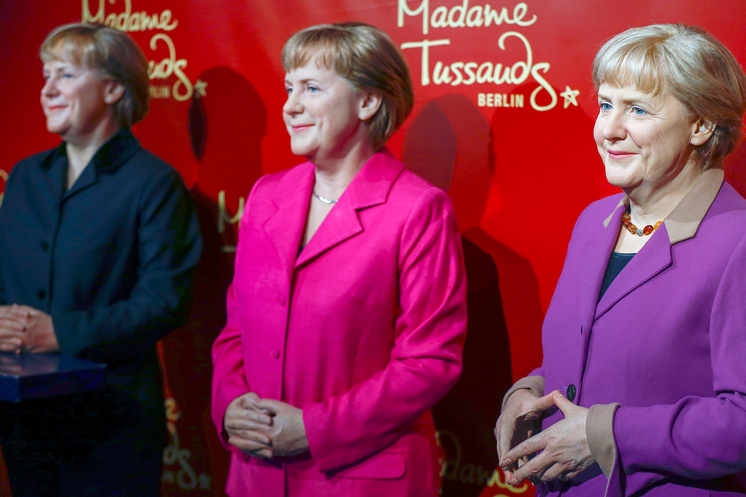 Three wax figures of Angela Merkel show her 10 years in office