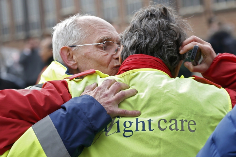 Los trabajadores del aeropuerto se abrazan tras ser evacuados (REUTERS/Francois Lenoir)