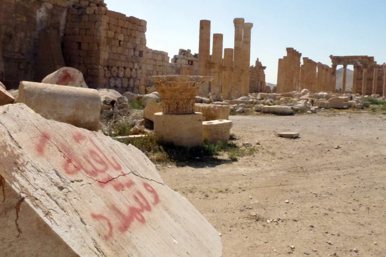 Un grafiti en árabe sobre los restos de una columna de la ciudad antigua de Palmira. (MAHER AL MOUNES / AFP)
