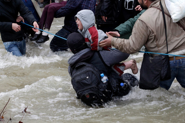 Refugiados intentan cruzar un río cerca de la frontera entre Grecia y Macedonia (REUTERS / Alexandros Avramidis)
