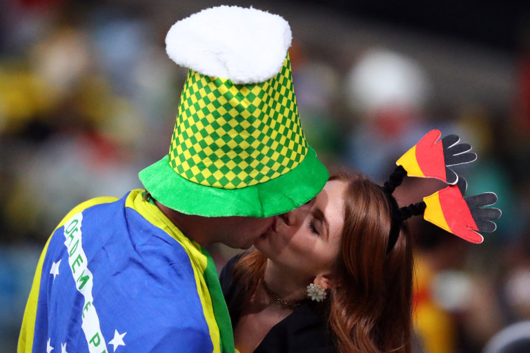 Un asistente vestido con los colores de Brasil besa a una asistente con los colores de Alemania (Foto: Lucy Nicholson / REUTERS)