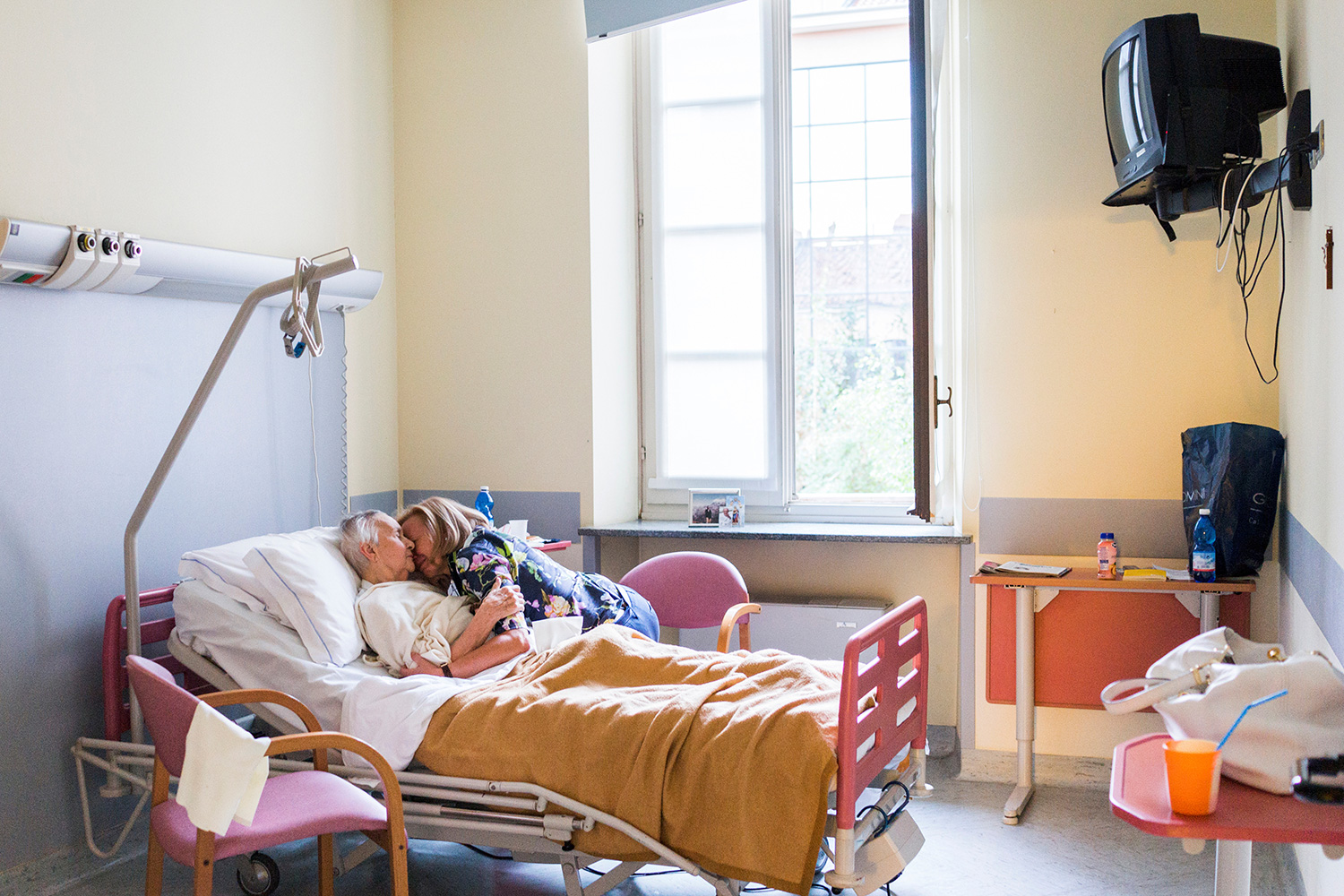 Chiara Micheletti abraza a su madre en la habitación de un hospital donde permaneció el último mes y medio de su vida (Gaia Squarci/Reuters)