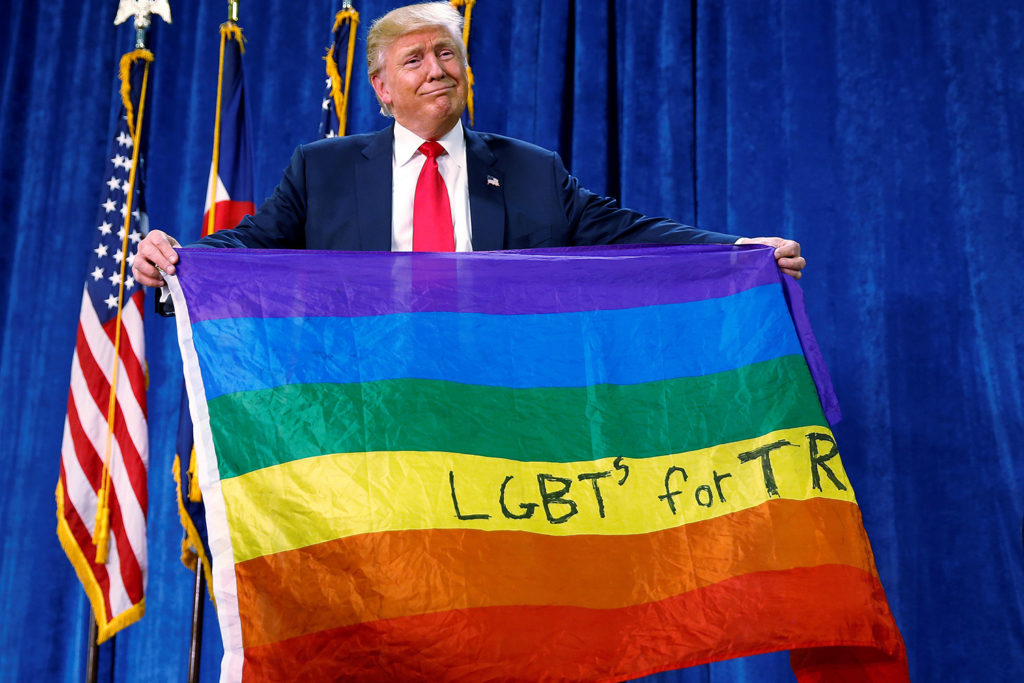 Trump sostiene (del revés) una bandera LGTB en un mitin en Colorado. (Foto: Carlo Allegri / Reuters)
