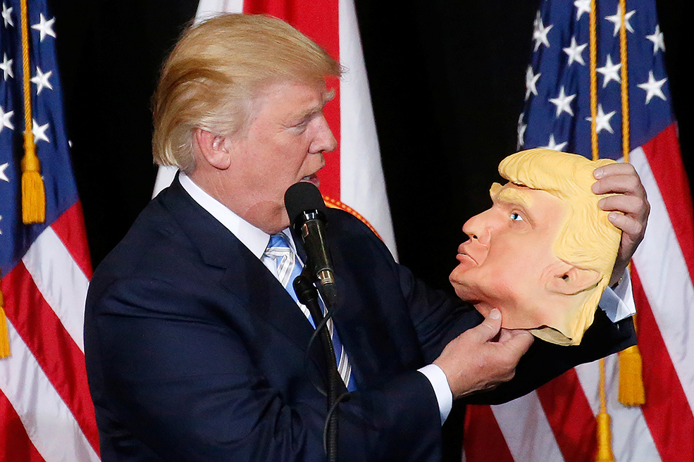 Donald Trump mira fijamente a una máscara con su cara (Foto: Carlo Allegri / Reuters)
