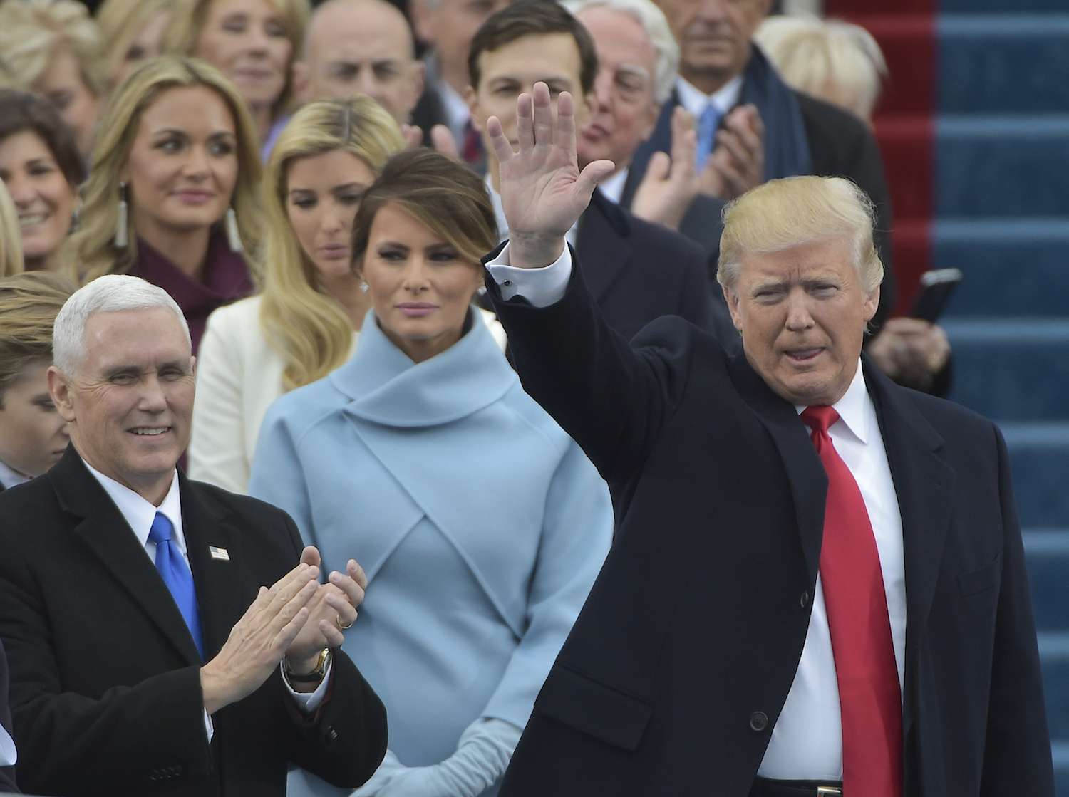 Vice-president elect Mike Pence (L) applauds as President-elect Donald Trump waves to the crowd as he arrives on the platform at the US Capitol in Washington, DC, on January 20, 2017, before his swearing-in ceremony. / AFP PHOTO / Mandel NGAN