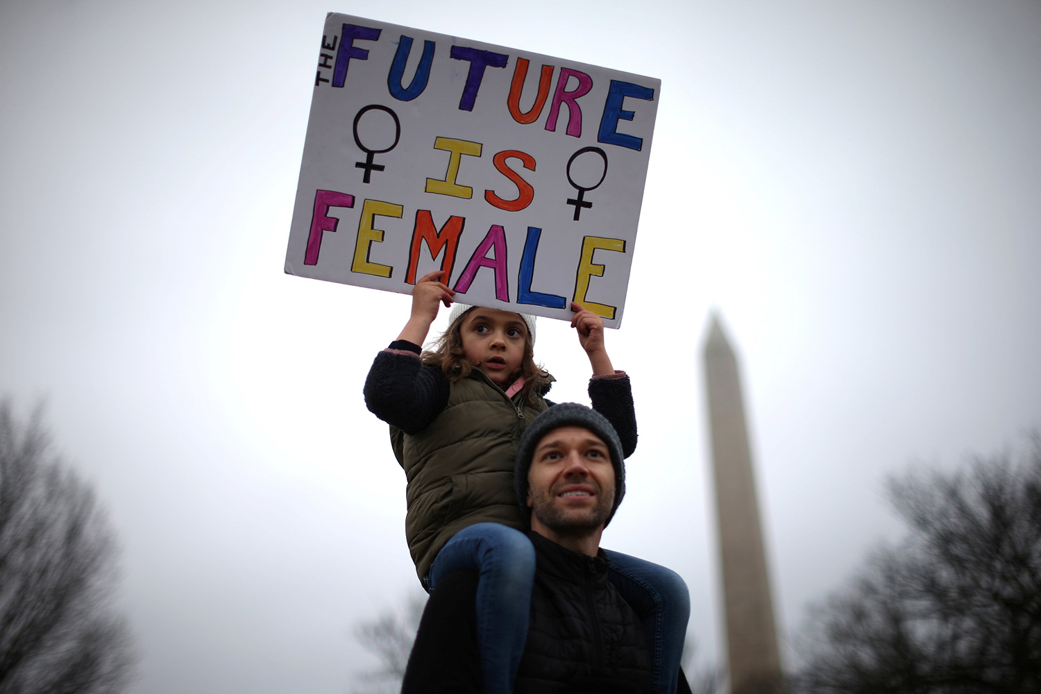 Una niña, a hombros de su padre, sostiene un cartel que reza “el futuro es femenino”. (Foto: Lucy Nicholson / Reuters)