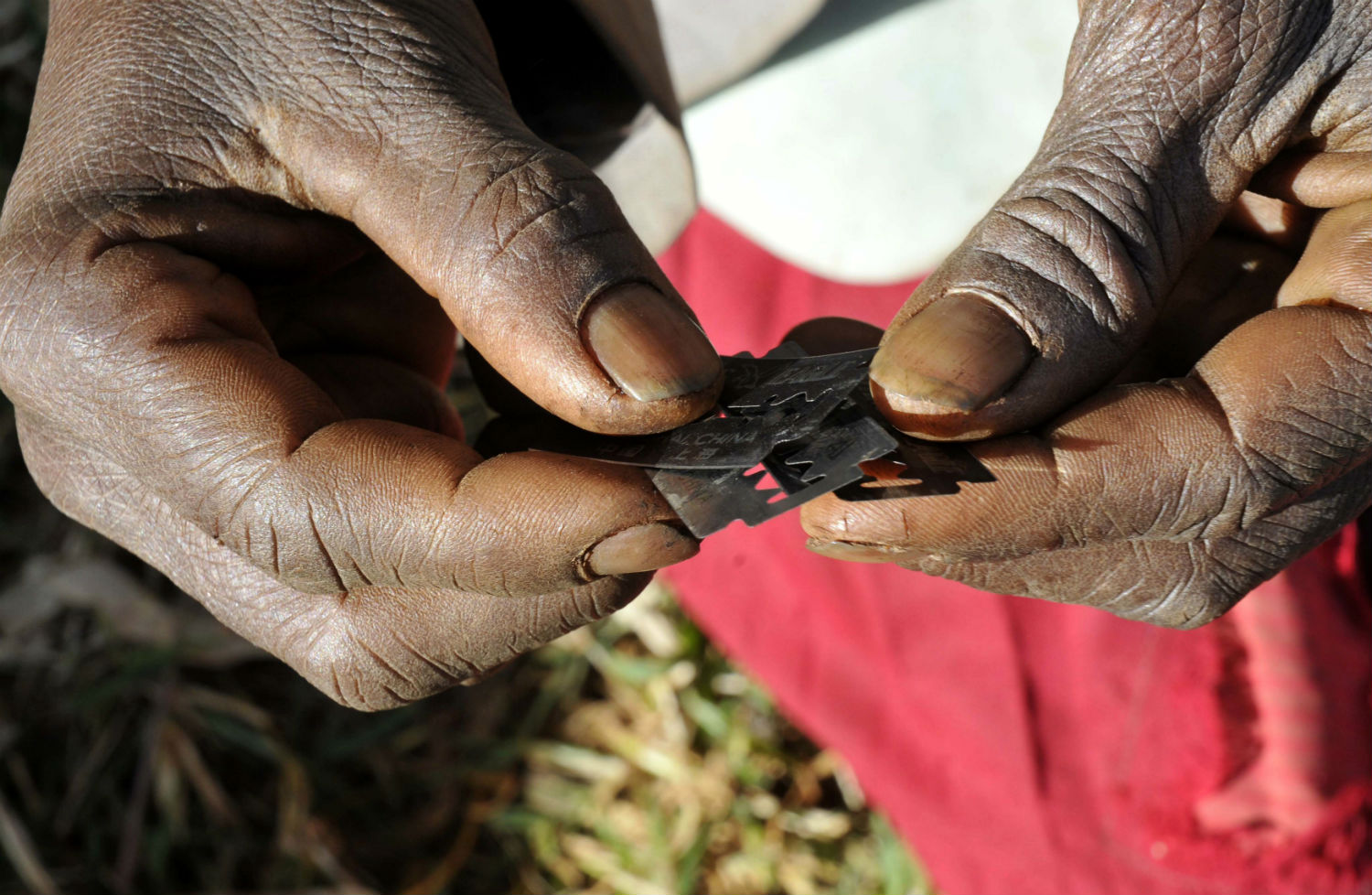 Prisca Korein, un cirujano tradicional de 62 años de edad, tiene hojas de afeitar antes de llevar a cabo la mutilación genital femenina en las adolescentes de la tribu sebei en el distrito Bukwa, a unos 357 km (214 millas) al noreste de Kampala, 15 de diciembre de 200