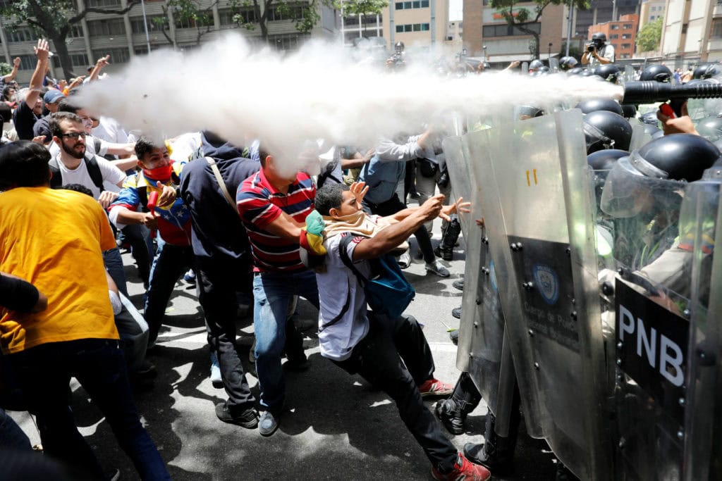 Los cuerpos de seguridad disparaban bombas de gas lacrimogeno a corta distancia contra los manifestantes. | Foto: Carlos García Rawlins / Reuters.