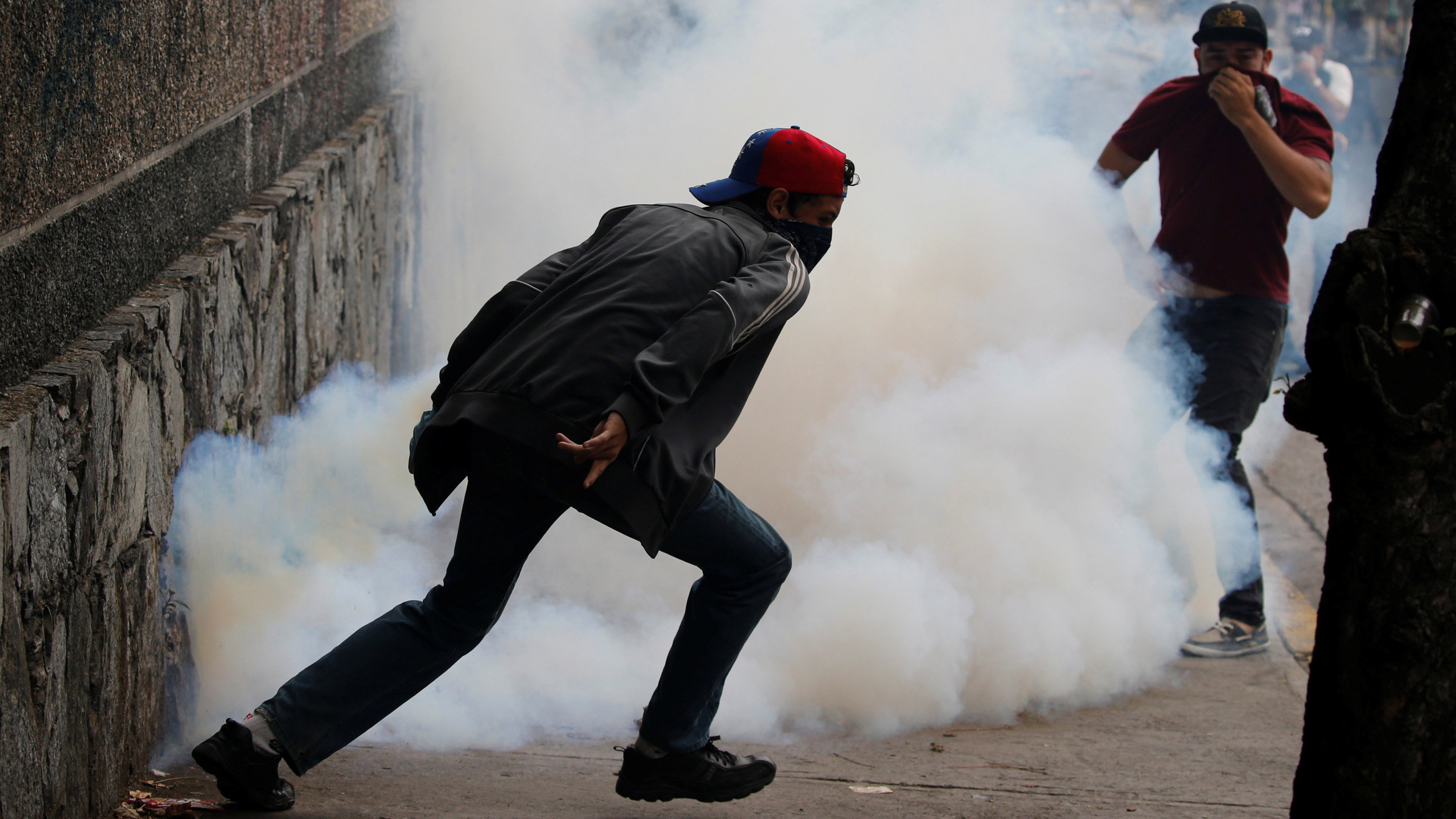 Demonstrators run away from tear gas during a protest against Venezuela's President Nicolas Maduro's government in Caracas, Venezuela May 2, 2017. REUTERS/Carlos Garcia Rawlins