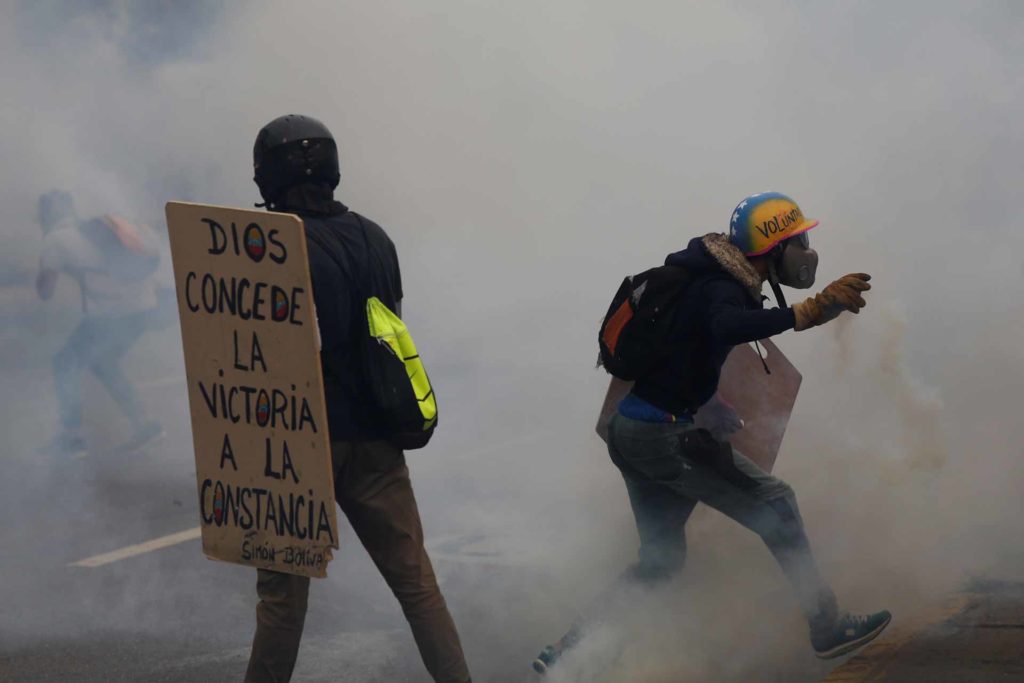 Los opositores más jóvenes se enfrentan con constancia a la represión de las marchas. | Foto: Marco Bello / Reuters