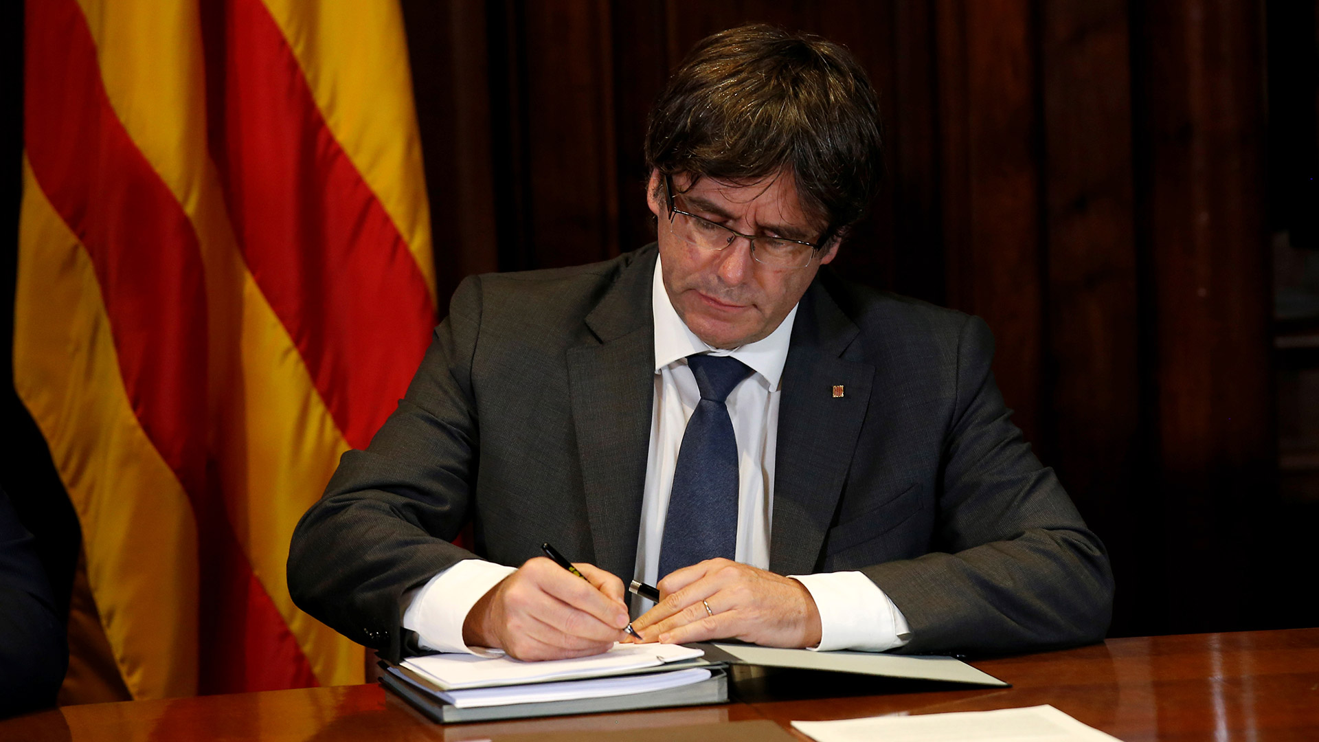 El presidente de la Generalitat de Cataluña, Carles Puigdemont, firma la Ley del Referéndum. | Foto: Albert Gea