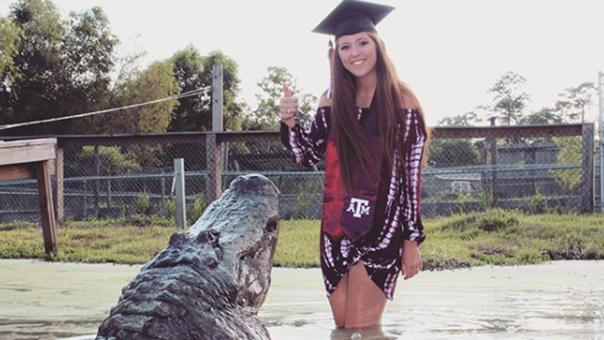 Una joven de Texas posa en su graduación junto a un inmenso cocodrilo