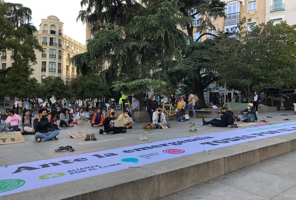 Activistas de Fridays For Future protestan sentados y con mascarilla ante el Congreso de los Diputados