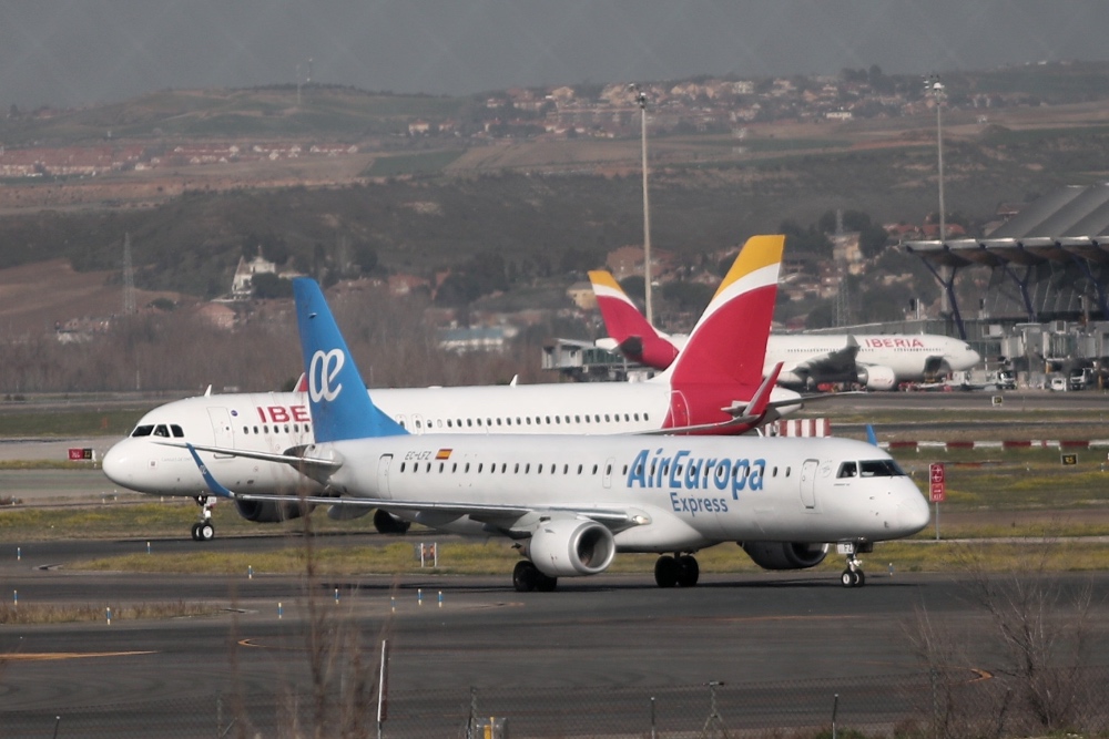 Aviones de Iberia y Air Europa aparcados en una pista de aterrizaje.