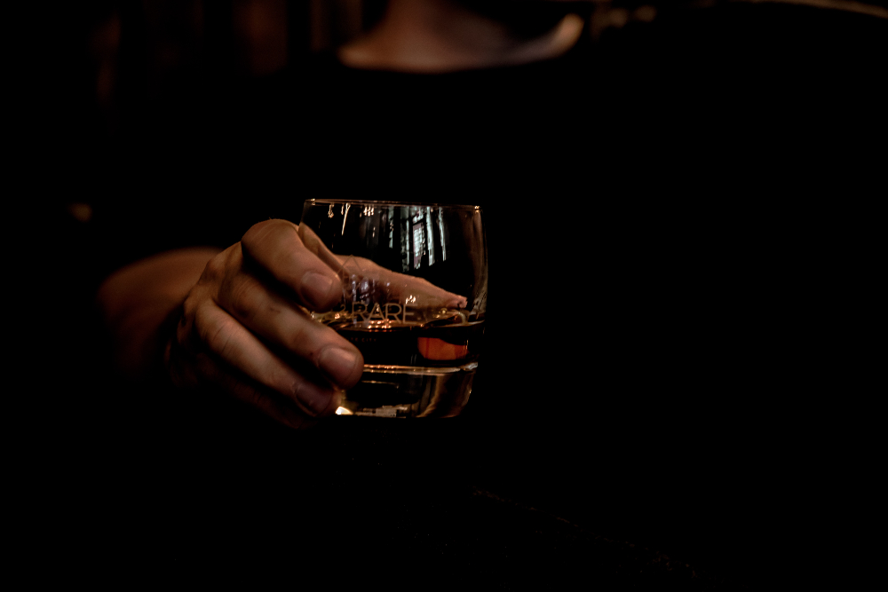 Un hombre sujeta un vaso con alcohol
