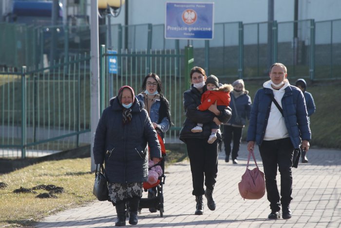 Ucranianos traspasan a pie la frontera entre Ucrania y Polonia.