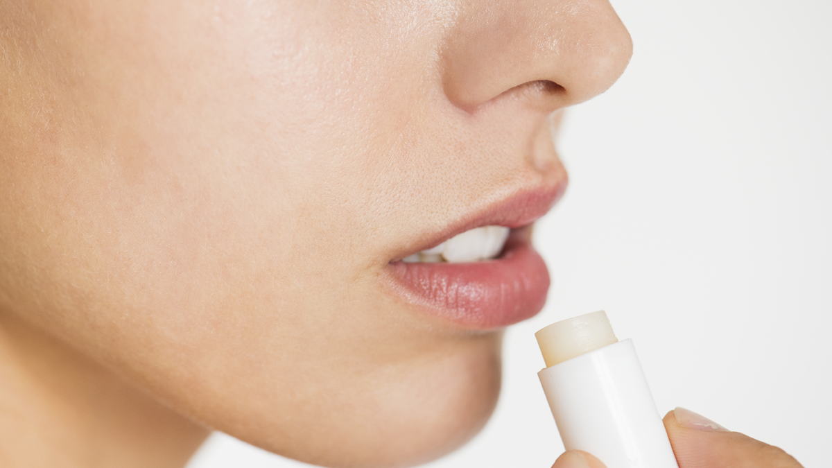 Mujer utilizando un bálsamo labial (Freepik/rawpixel)