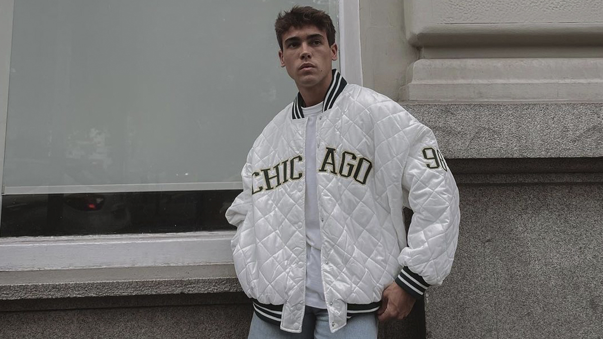 Alex Cuenca con una bomber blanco con detalles a rayas