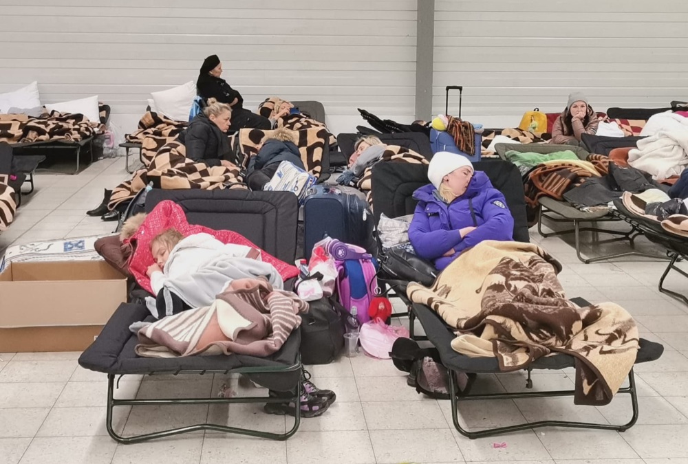 Varios ucranianos descansan en el centro de refugiados de Korczowa, en Polonia