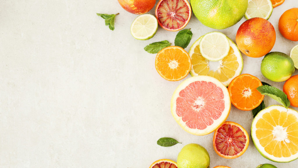 Vista superior de varias frutas cítricas cortadas en rodajas como naranja, pomelo, lima, limón o sanguina