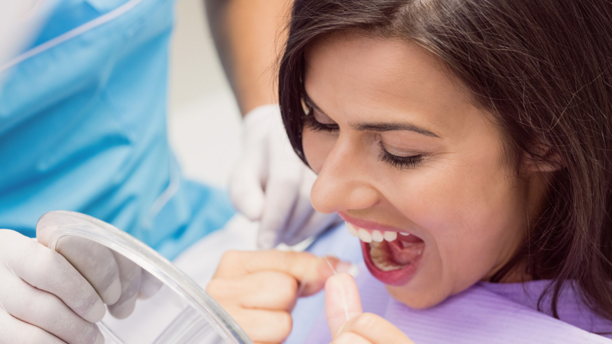 Una mujer aprende a utilizar seda dental, clave en la higiene dental.