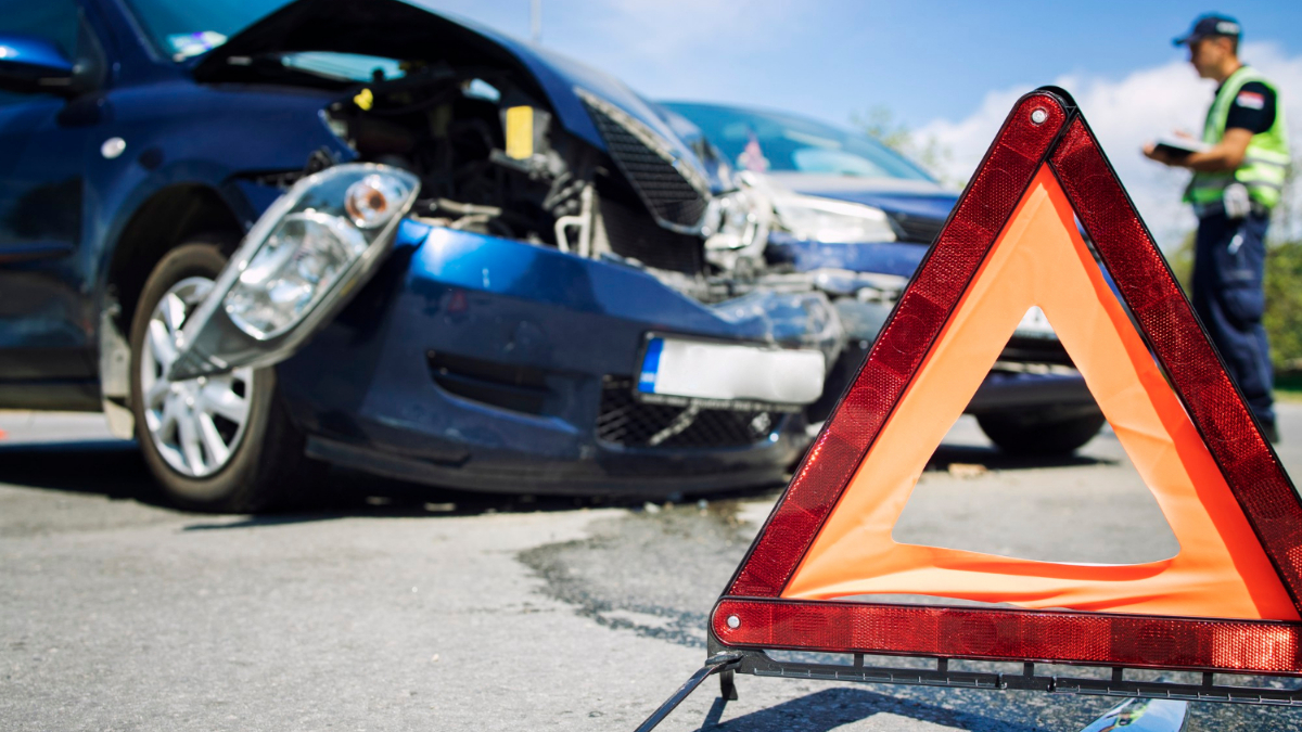 Un policía toma nota de un accidente de tráfico entre dos coches