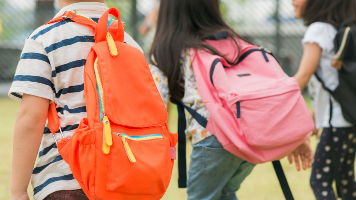 Varios niños caminan con sus mochilas a la vuelta del cole