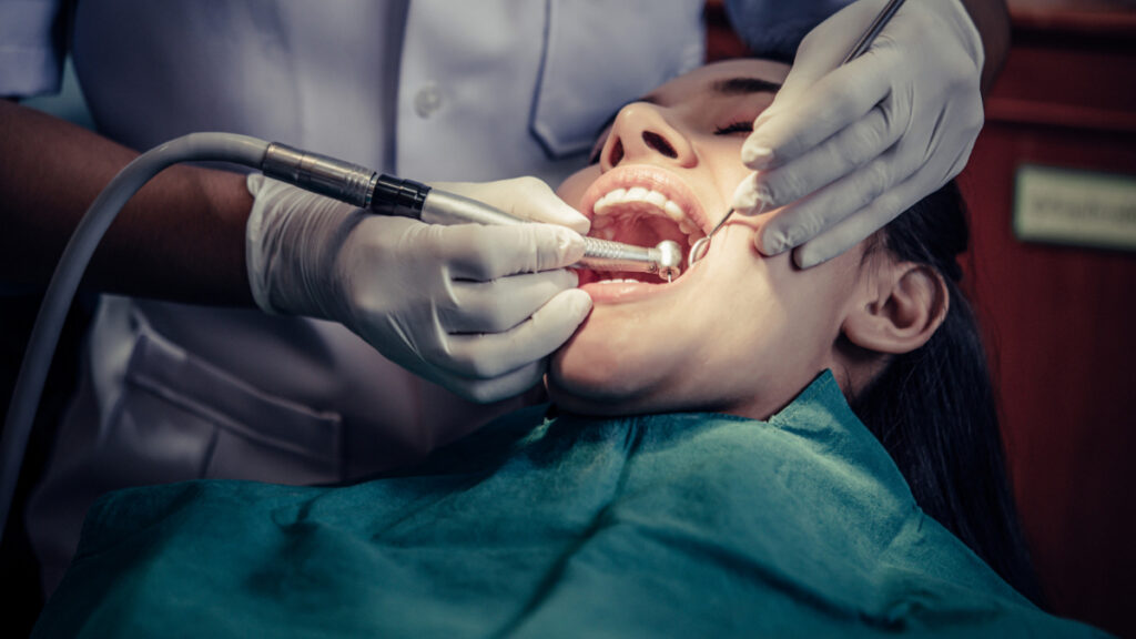 Un dentista trabaja sobre la boca de una mujer