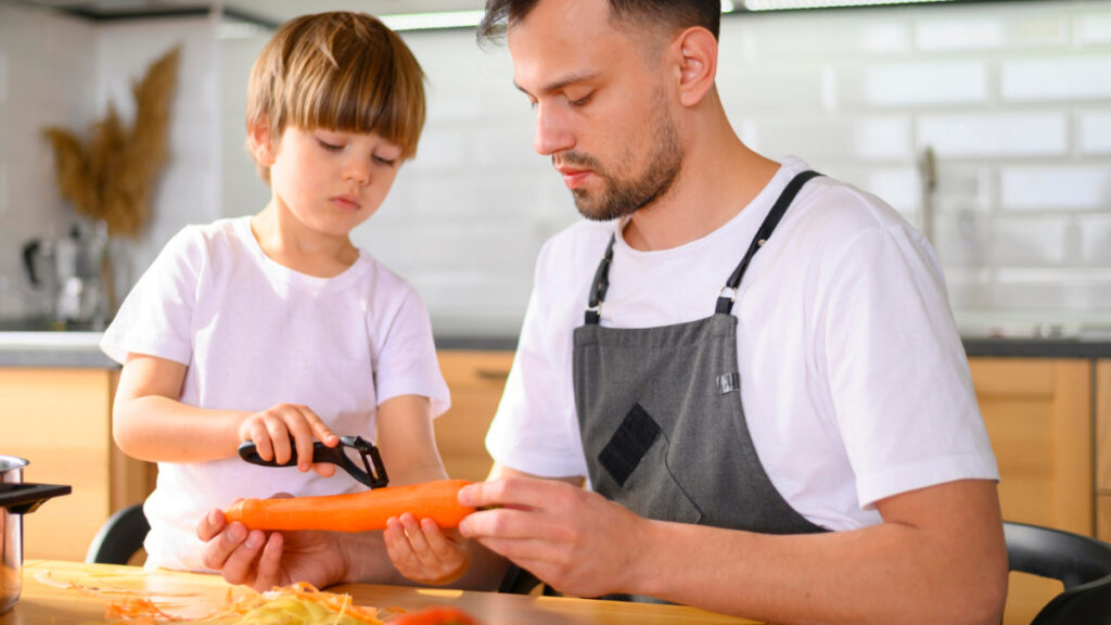Un padre y un hijo pelan una zanahoria