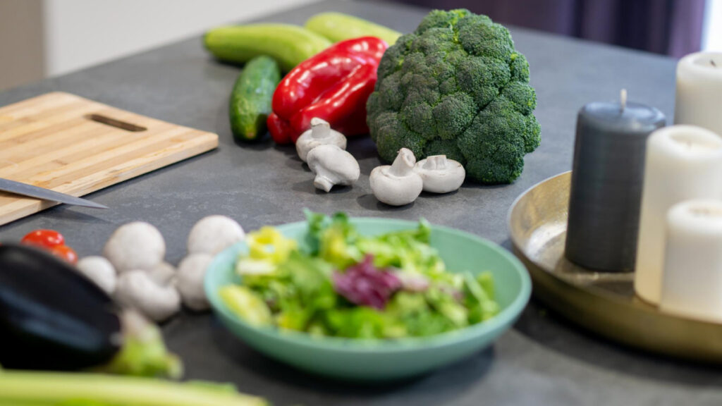 Varias verduras en una mesa junto a una ensalada