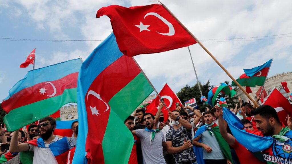 Hombres azeríes que viven en Turquía ondean banderas de Turquía y Azerbaiyán durante una protesta tras los enfrentamientos de 2020. 