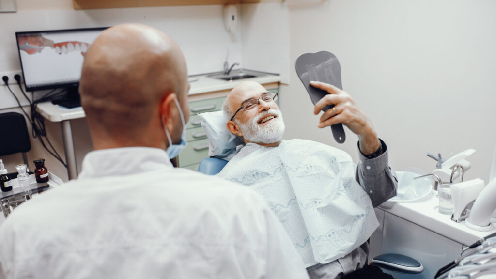 Un hombre mayor refiere problemas de gingivitis a su dentista