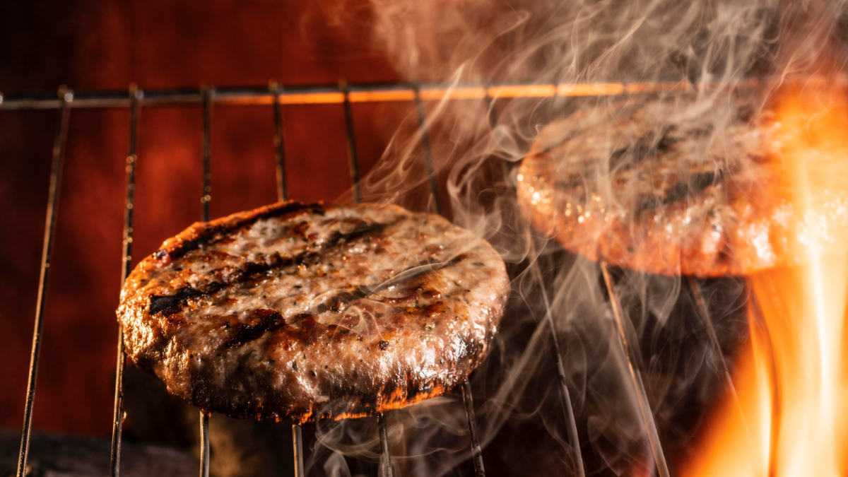 Dos hamburguesas cocinándose a la parrilla