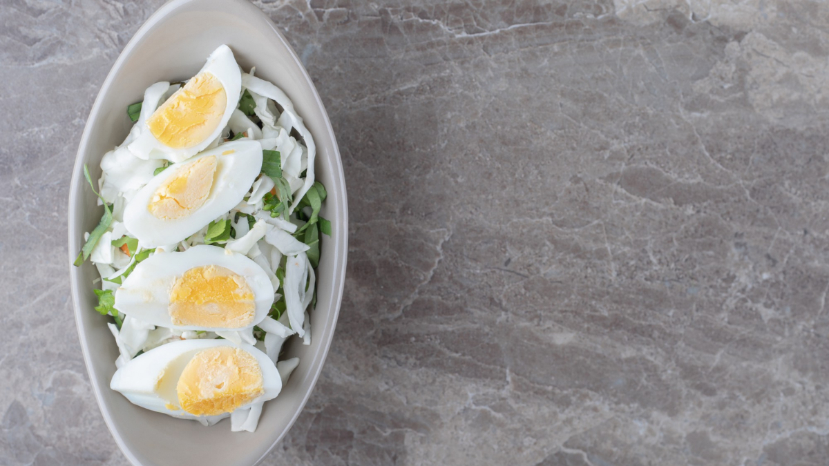 Huevos cocidos sobre una ensalada de lechuga y cebolla