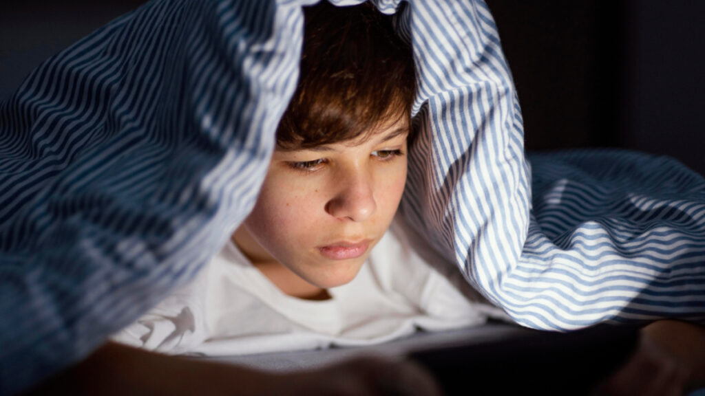 Un adolescente realizaba un pin al utilizar el teléfono móvil en la cama por la noche.