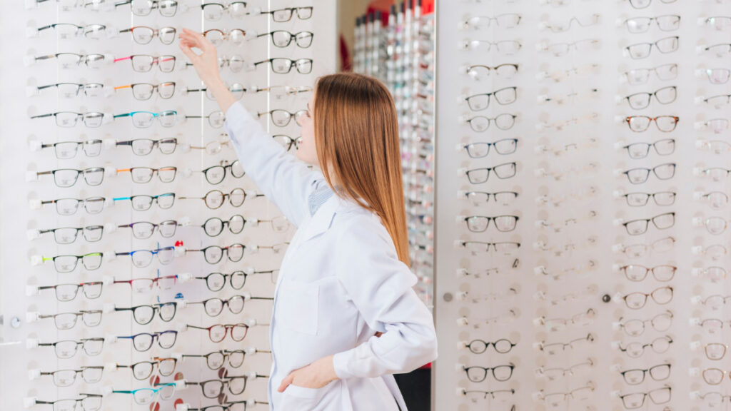 Una mujer coloca gafas de farmacia en una estantería.