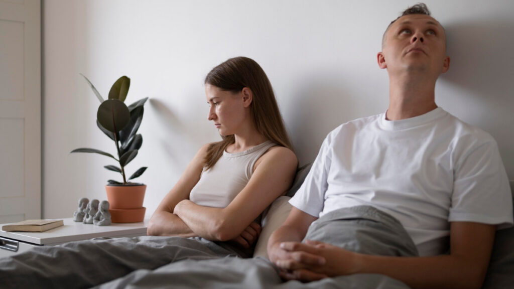 Una pareja descontenta en la cama tras tener sexo.